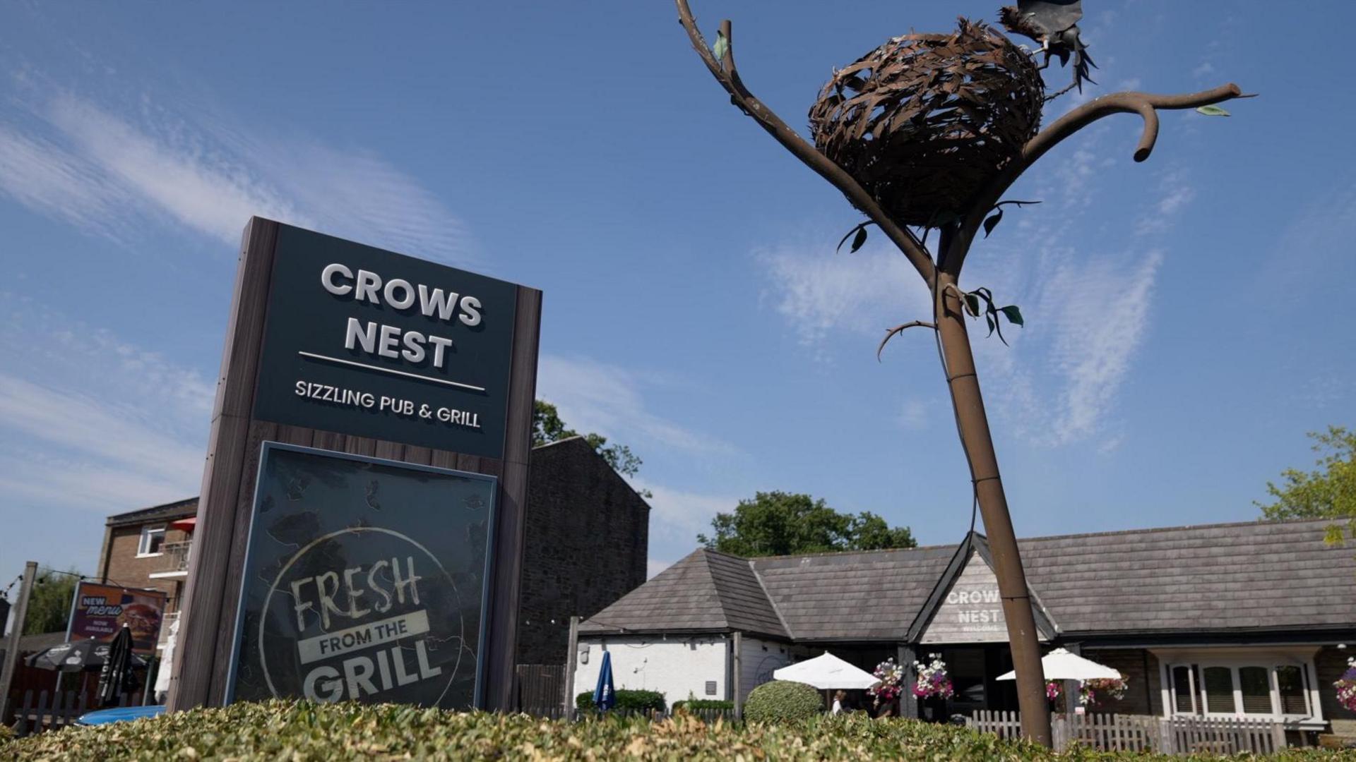 The Crow's Nest Pub exterior with a crows nest in the foreground of the image
