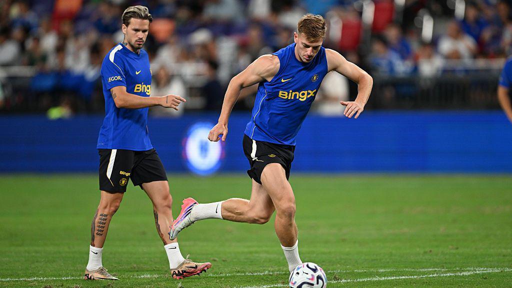 Mykhailo Mudryk stood behind Liam Delap who is preparing to shoot