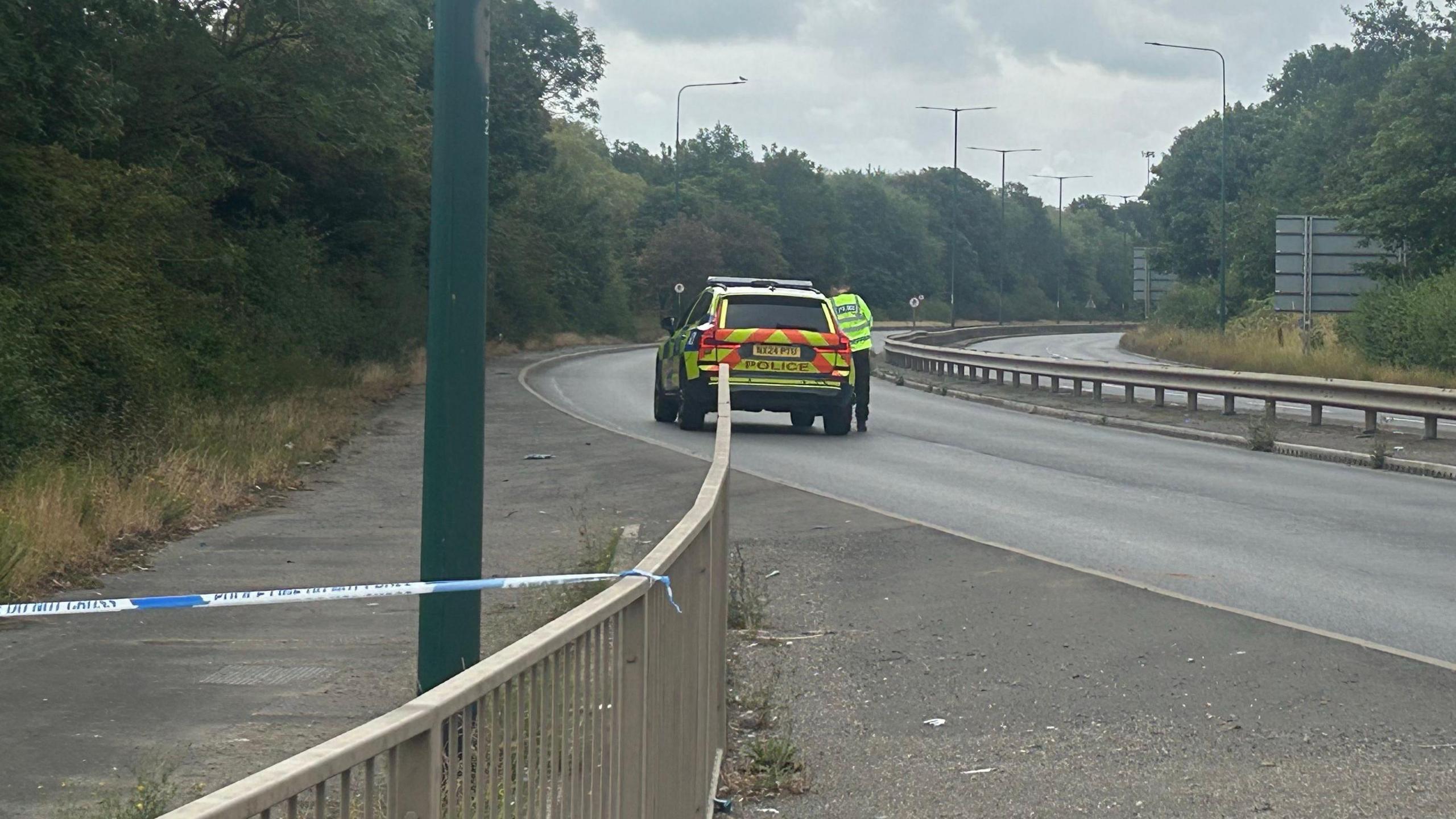 The closed section of the A66. A police car is parked on the silent, empty, dual-carriageway.
