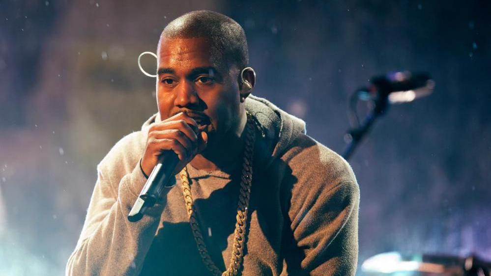 Kanye West performs with U2 during a surprise concert in support of World AIDS Day in Times Square in New York