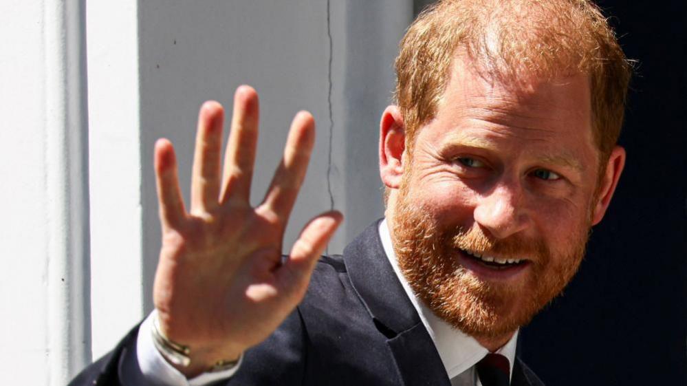 Close up photo of Prince Harry smiling and waving
