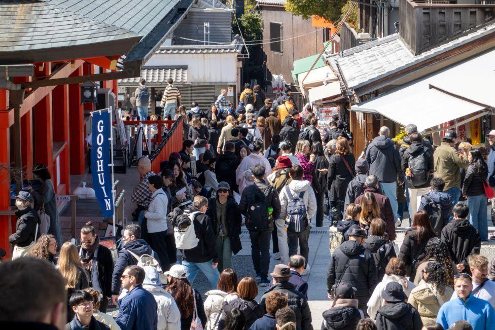 Huge crowds of tourists fill a street in Kyoto