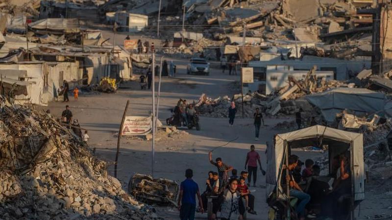 A wide view of displaced Palestinians walking between destroyed houses in Jabaliya, northern Gaza City, on 7 August.