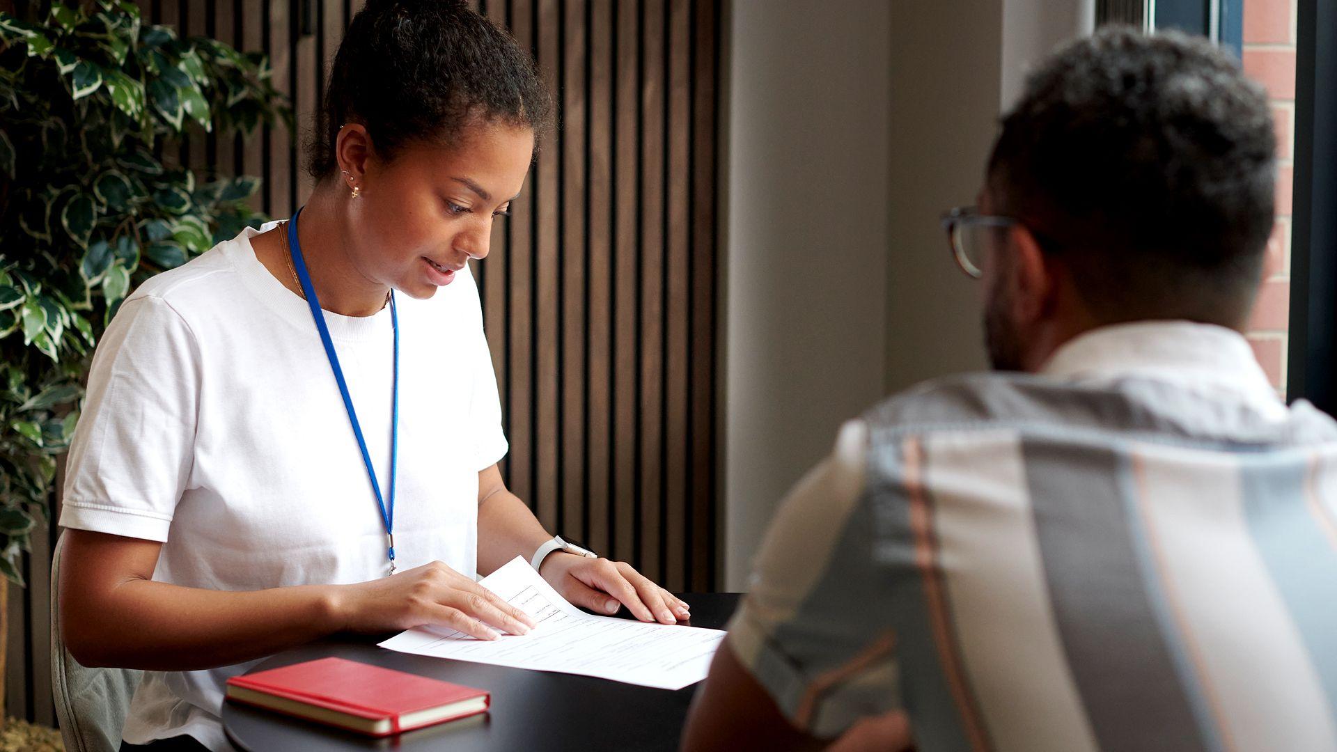 A young woman in a modern office at a table with a co-worker