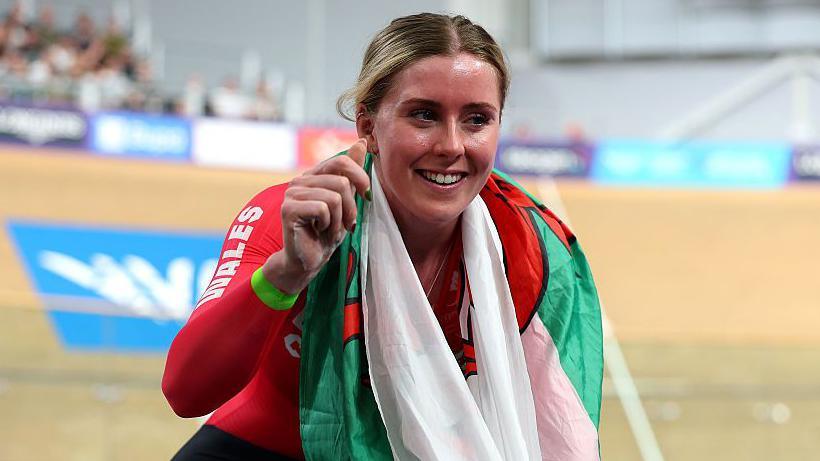 Emma Finucane celebrated on her bike with Welsh flag
