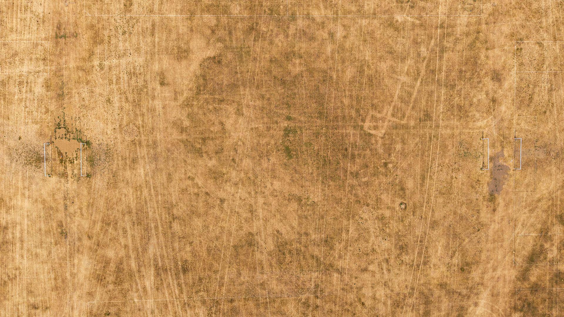 In this aerial view drought-damaged football pitches are seen on Hackney Marshes on July 23, 2026 in London, United Kingdom.