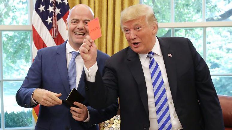 US President Donald Trump pretends to give a red card to members of the media while meeting with Fifa President Gianni Infantino at the White House in August 2018