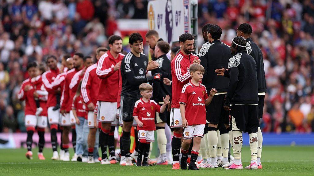 The sons of PC Matthew Blades join Bruno Fernandes in leading out Manchester United at Old Trafford. They are pictured shaking hands with Ipswich players