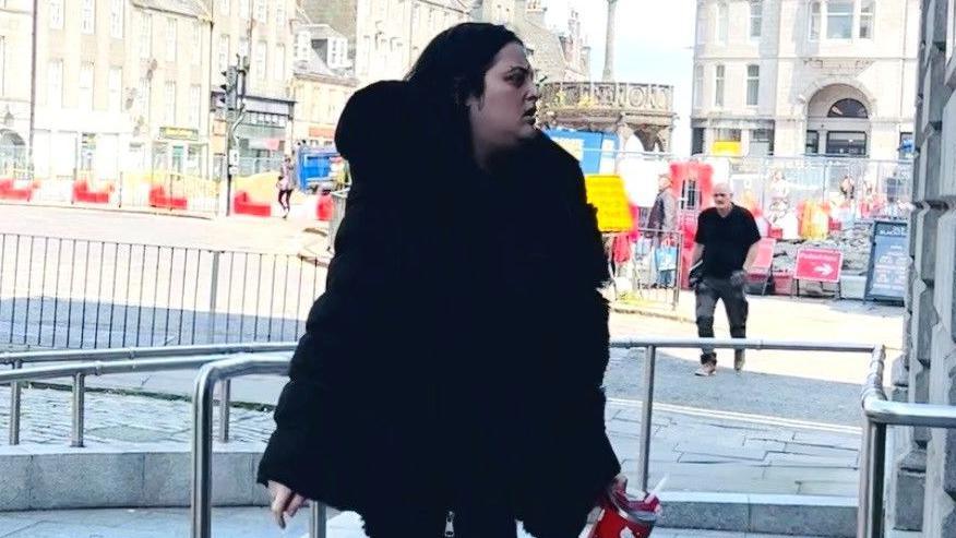 Courtney Gartshore, dressed in black, arrives at the High Court in Aberdeen.