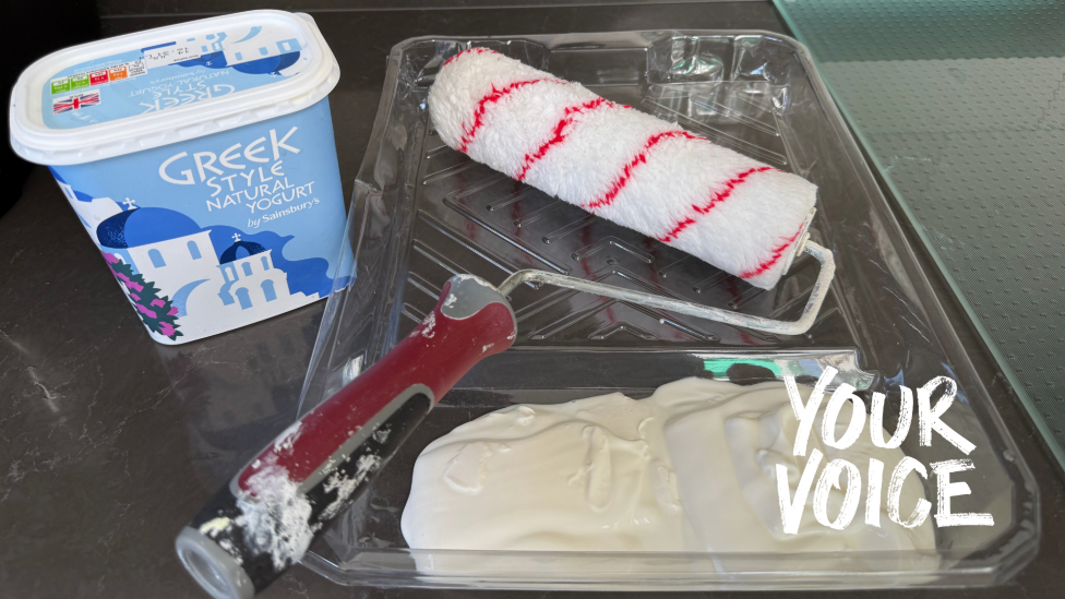 A paint roller next to a tub of Greek yoghurt