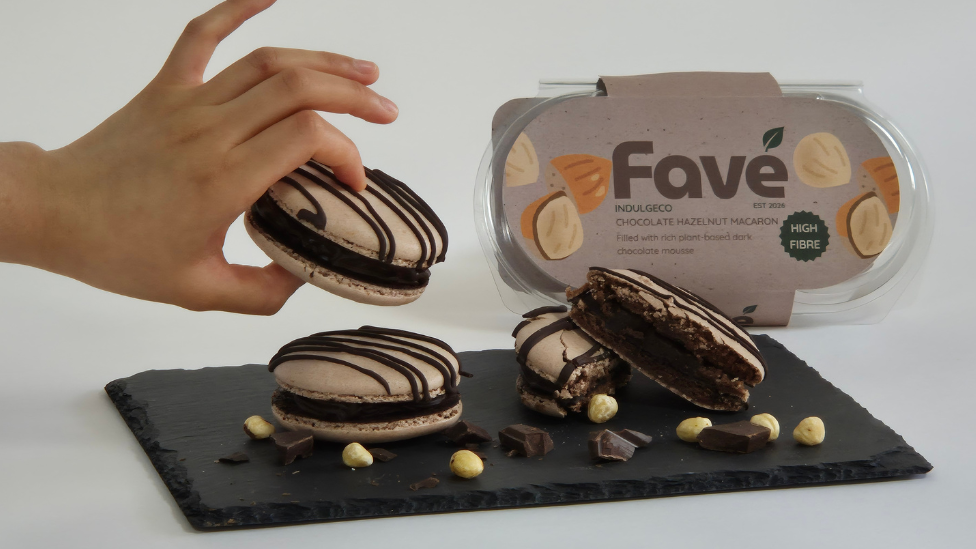 Three chocolate macarons on a black slate board