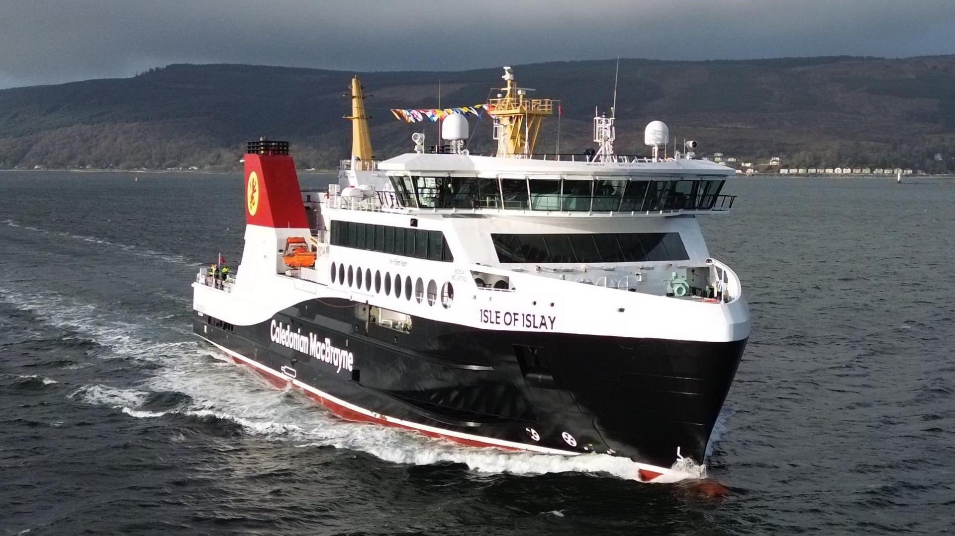 A black and white ferry on water with Caledonian MacBrayne written on it, with Isle of Islay written near the front