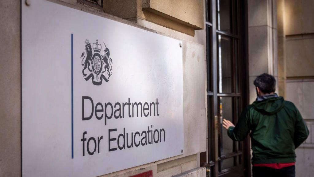 The Department for Education sign on a white brick building