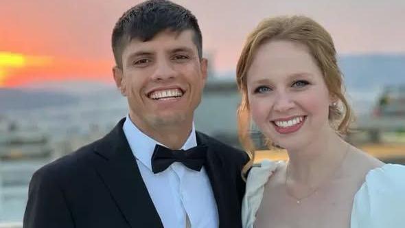 A wedding photo showing a man in an evening suit and a woman in a wedding dress, smiling.