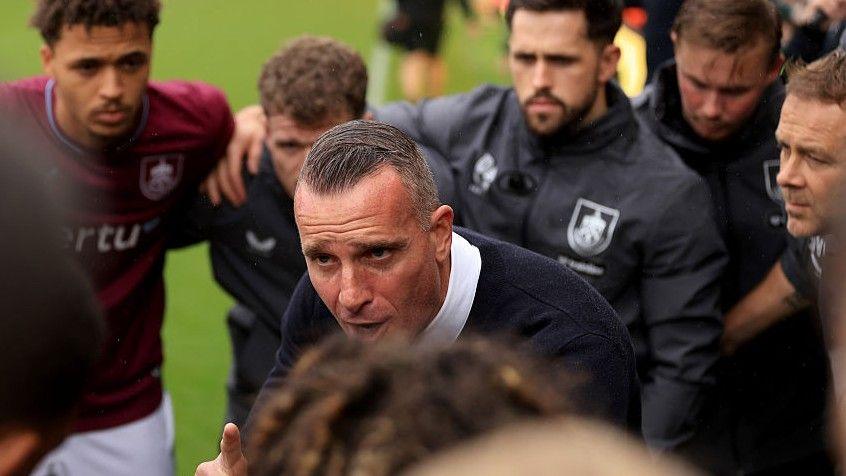 Burnley boss Nicky Hayen adresses players in a huddle on the pitch