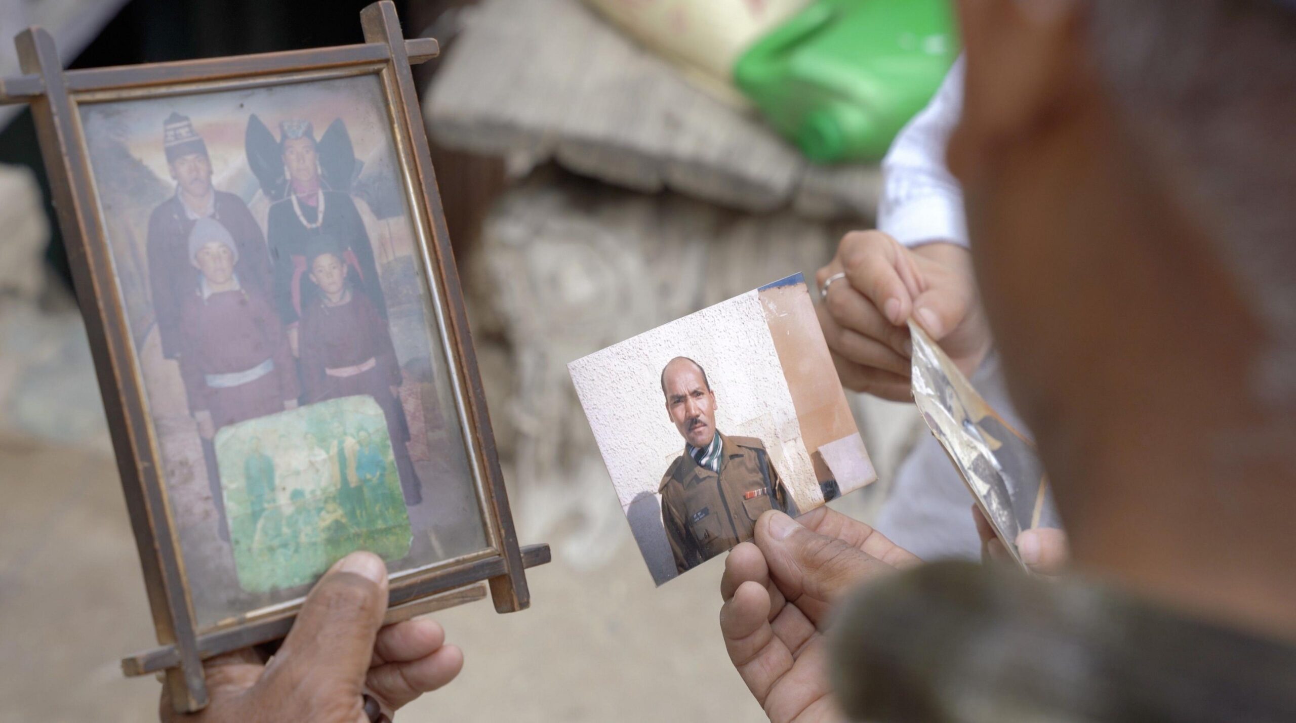 A man holds old photographs in his hands