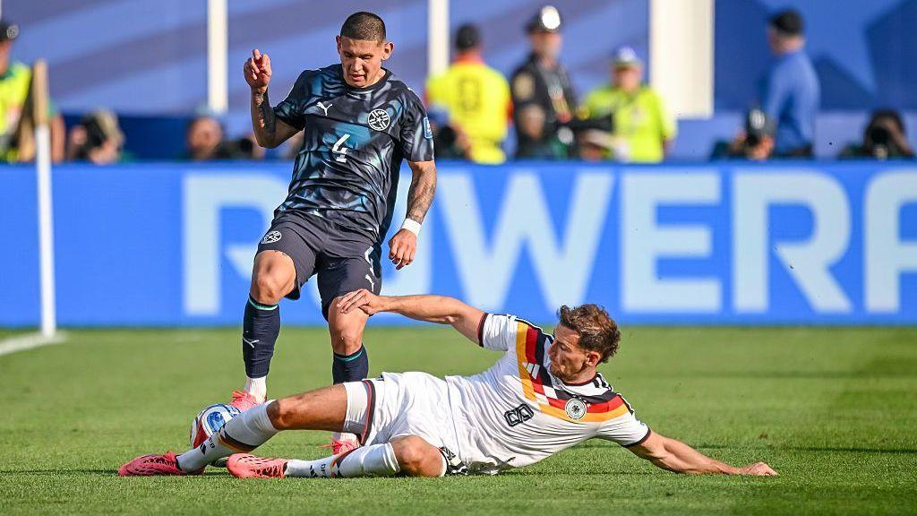 Leon Goretzka slides in to tackle Paraguay's Juan Jose Caceres during the World Cup