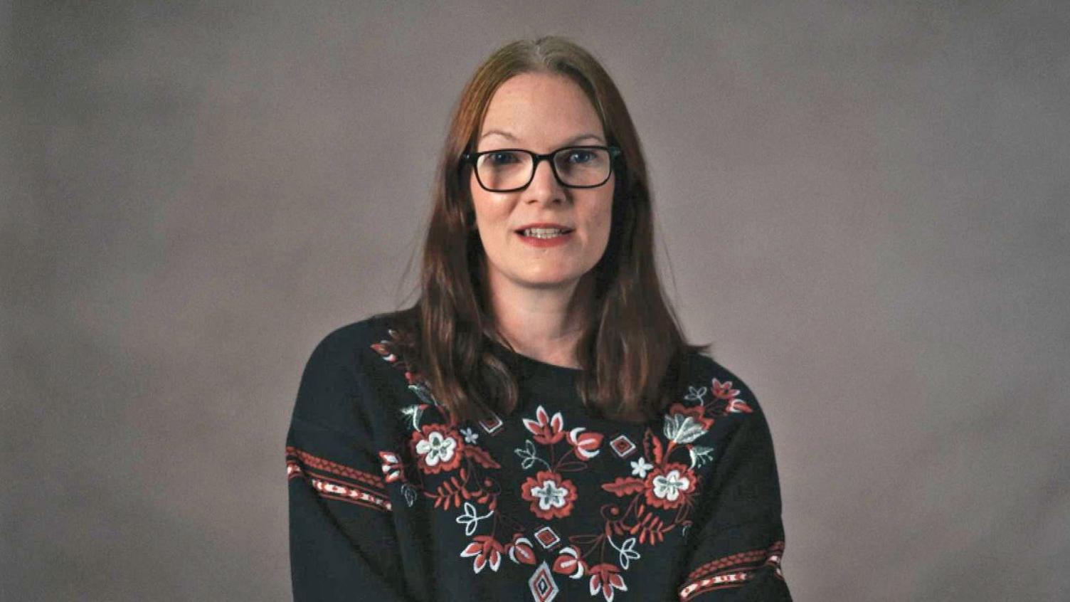 Zara, who wears glasses and a jumper with flowers on it, speaks to the BBC.