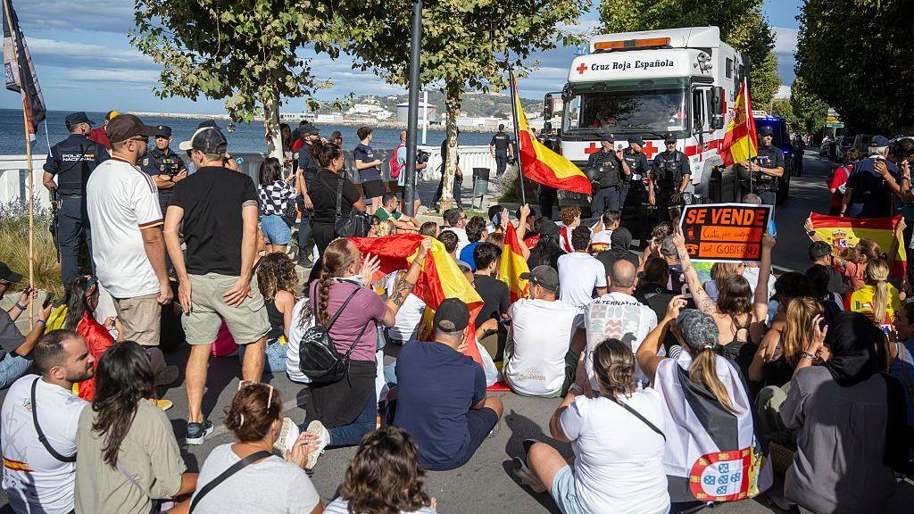 Demonstrators block a road where Red Cross volunteers are trying to gain access to distribute food parcels to migrants on Trampolin beach, Ceuta on Thursday.