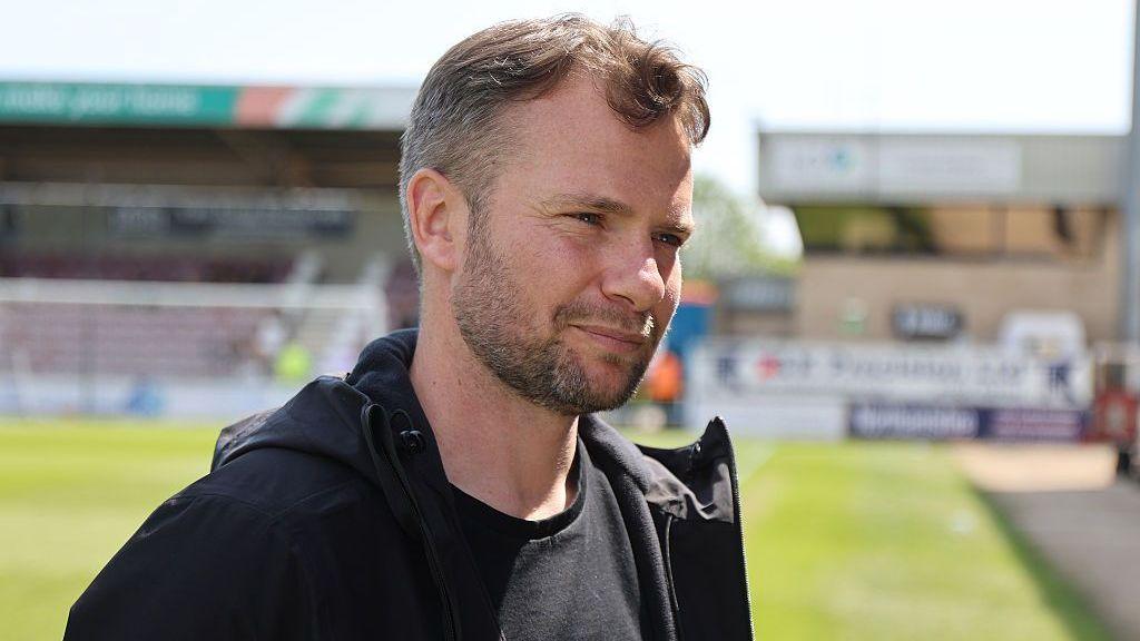 A smiling Tom Cleverley talking to the media after a game