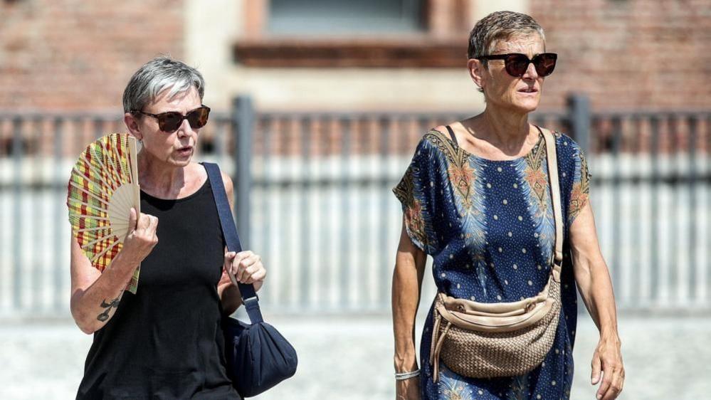 A person uses a fan on a hot summer day in Milan, Italy, 31 July 2026