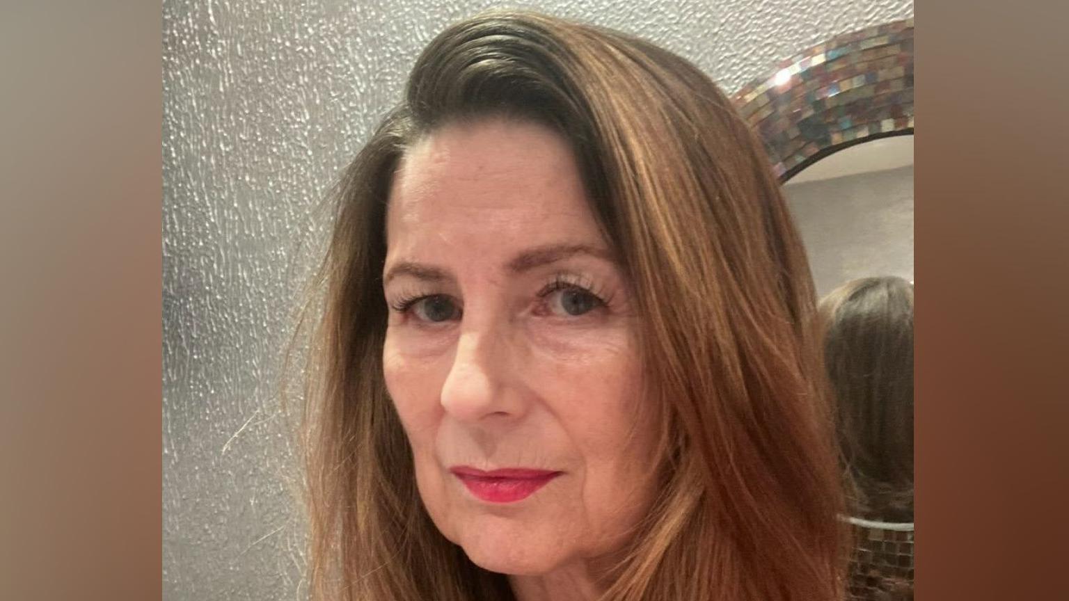 A selfie style image of a woman who is looking directly into the camera.
