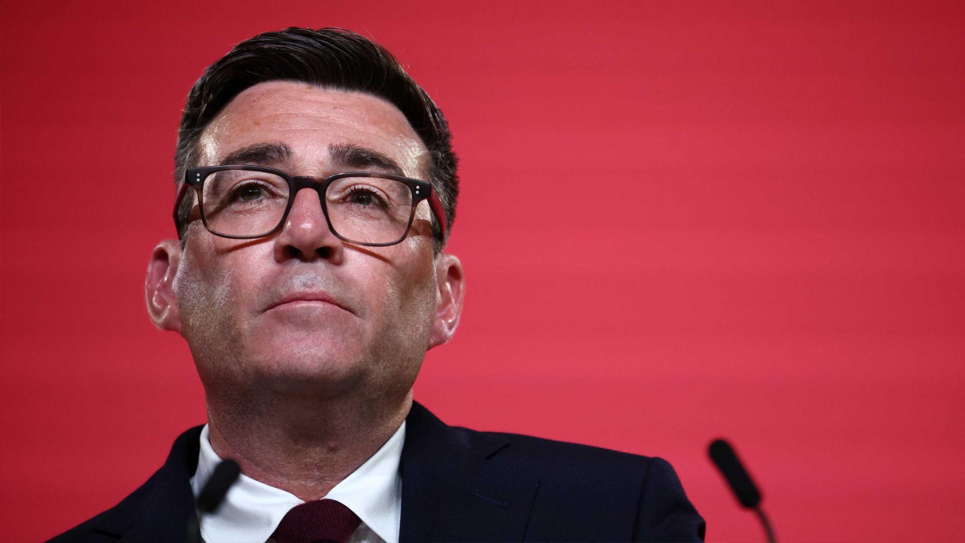 Andy Burnham against a red background