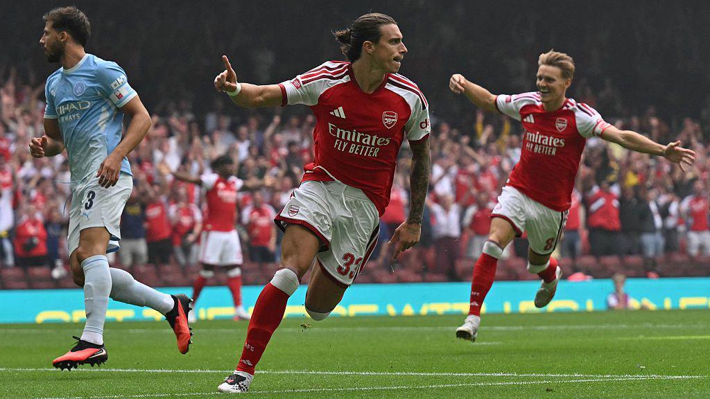 Riccardo Calafiori celebrates scoring for Arsenal with his finger raised in the air