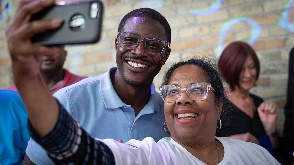David Crowley poses for a selfie alongside a supporter while campaigning to be the Democratic candidate for Wisconsin governor