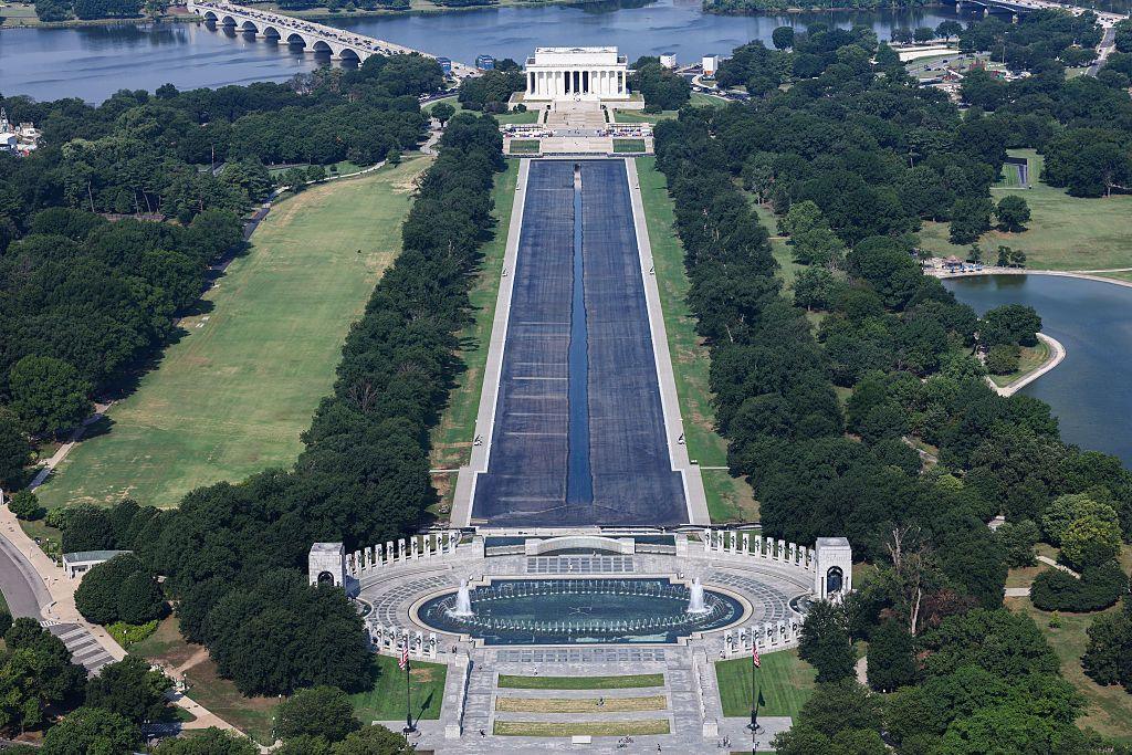 An aerial image of the Reflecting Pool shows it almost entirely drained, with the Lincoln Memorial in the background of the image
