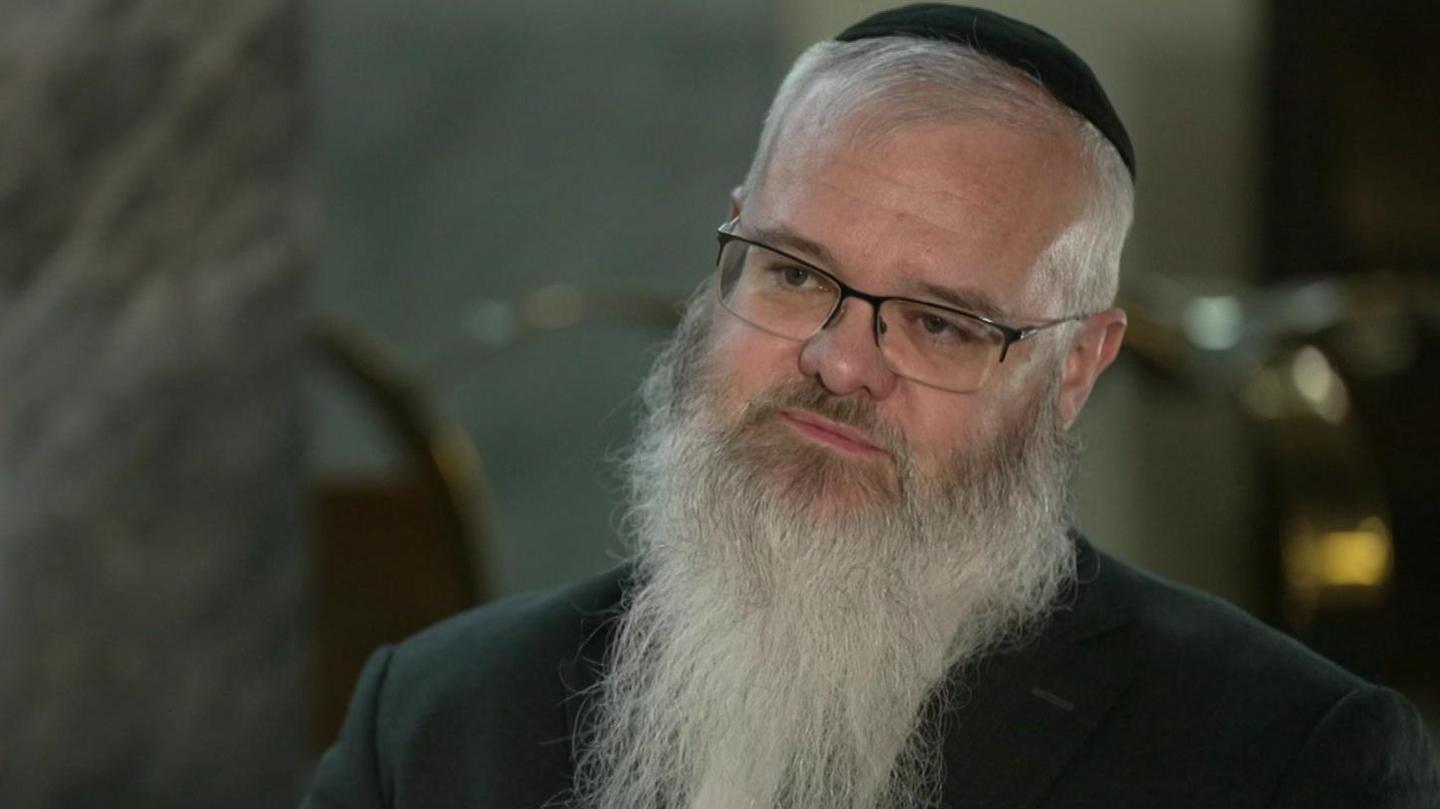Rabbi Daniel Walker. He is wearing a Kipa, glasses, and has a long grey beard.