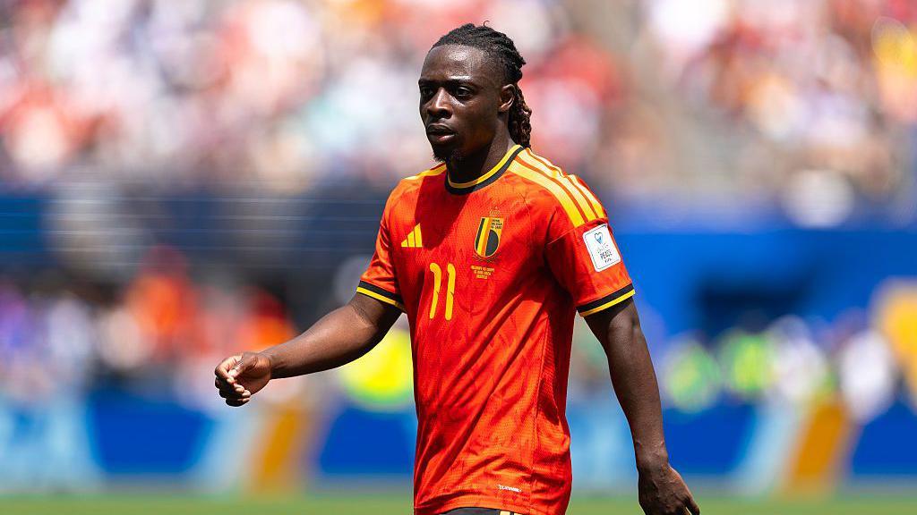 Jeremy Doku of Belgium looks on.