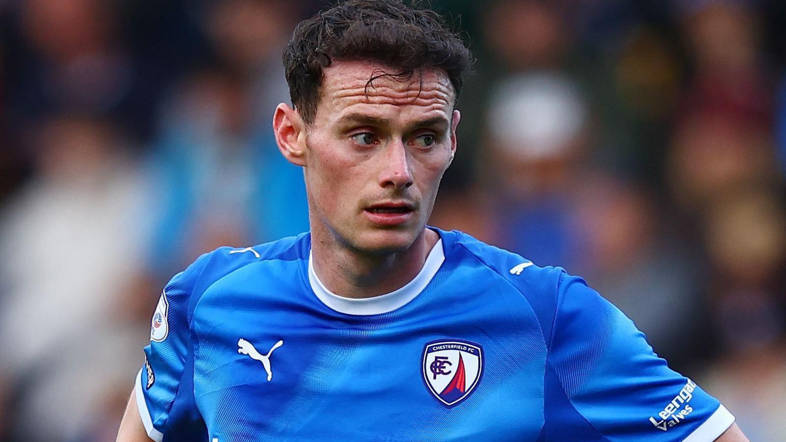 Liam Mandeville pictured wearing Chesterfield's blue home shirt with a white collar and sleeve ends in May 2026