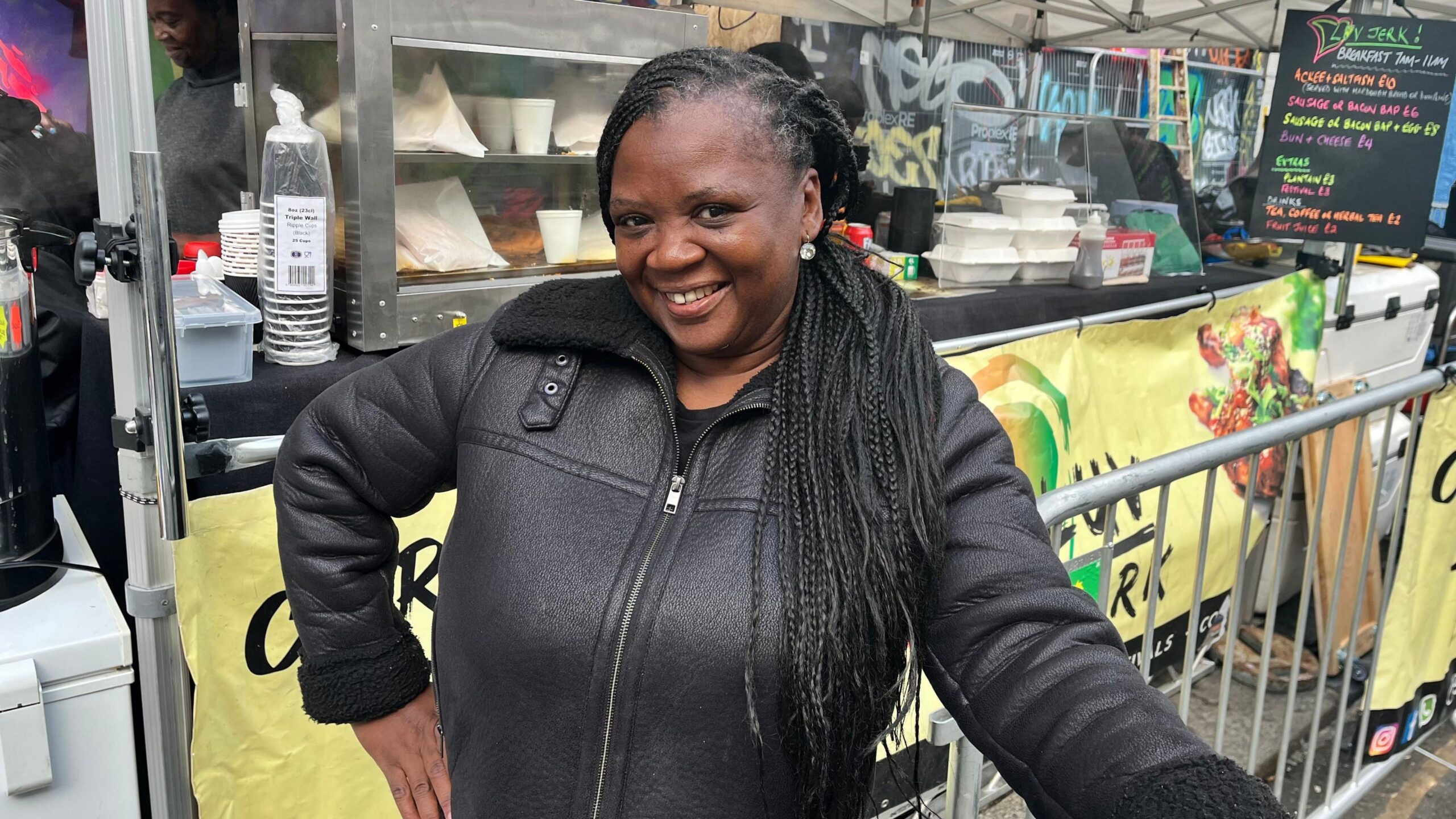 Lorraine in front of the Luv Jerk food stand.