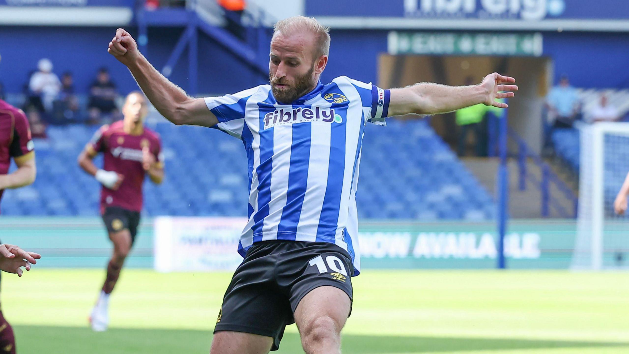 Barry Bannan wearing Sheffield Wednesday's blue and white striped home kit playing against Bolton Wanderers in the EFL Cup
