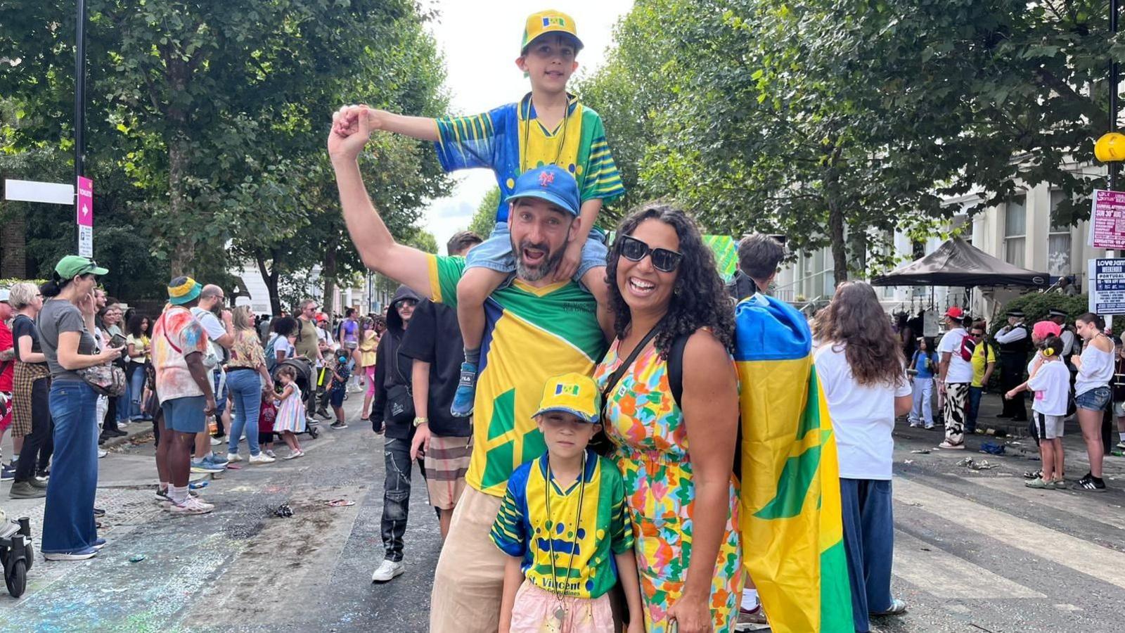 A family pose for a photo at the parade, dressed in yellow and green