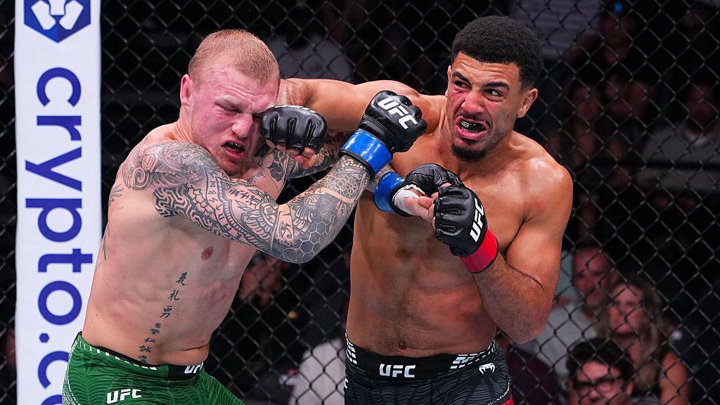 Mason Jones is punched by MarQuel Mederos in their UFC fight