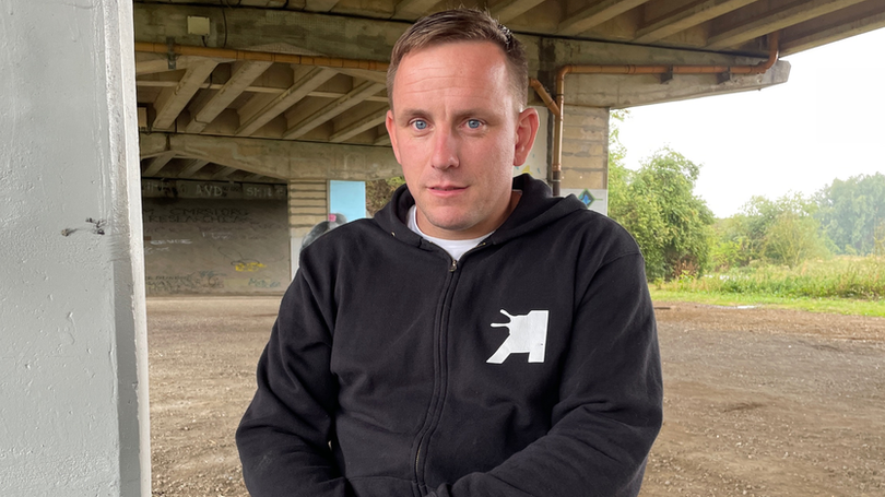 Nathan Murdoch is sitting beneath an underpass and has a can of paint in his hand.