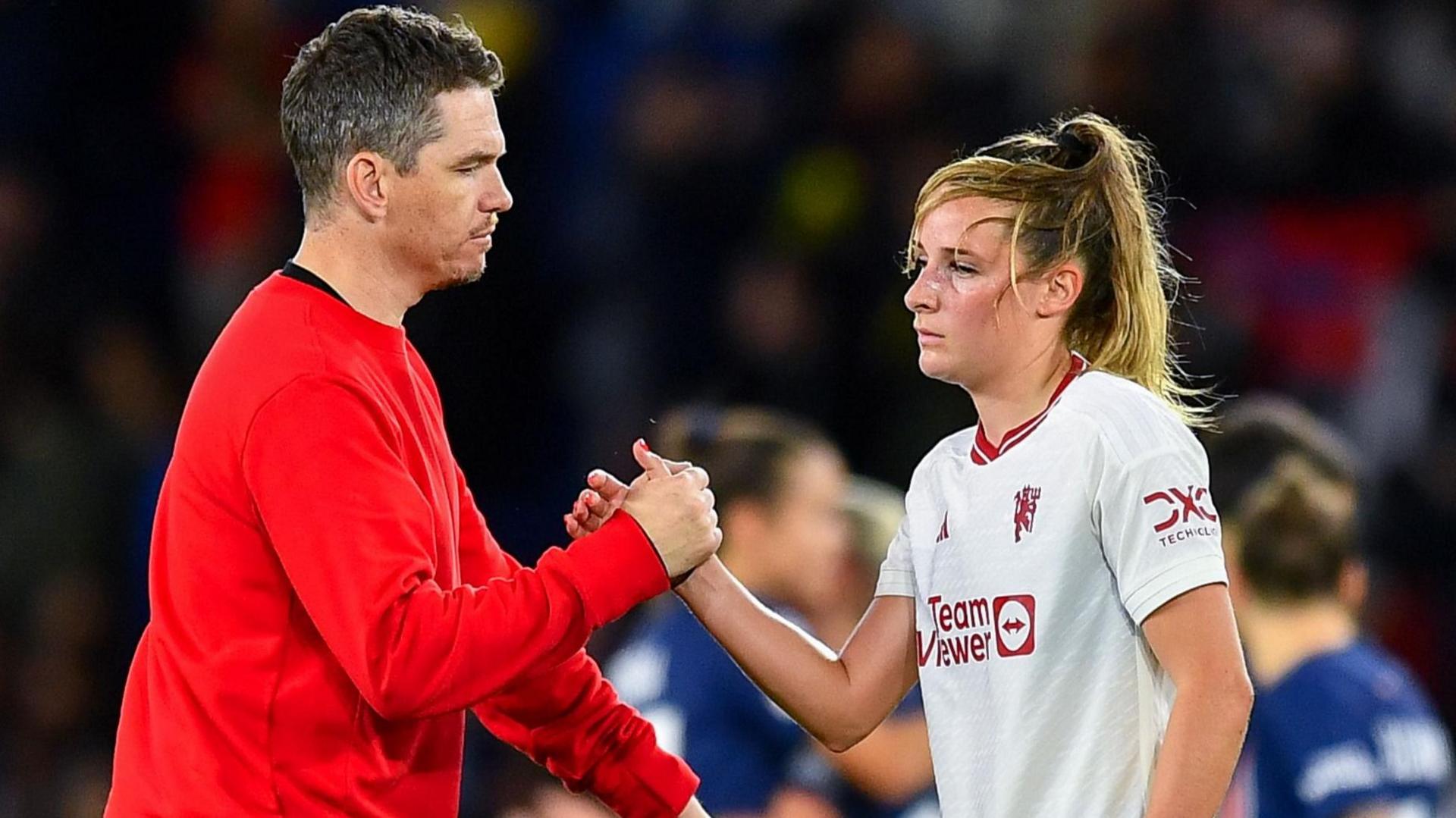 Marc Skinner shaking hands with Ella Toone