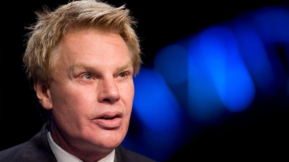Michael Jeffries, former CEO of Abercrombie and Fitch, seen in a suit against a black and blue background in December 2014