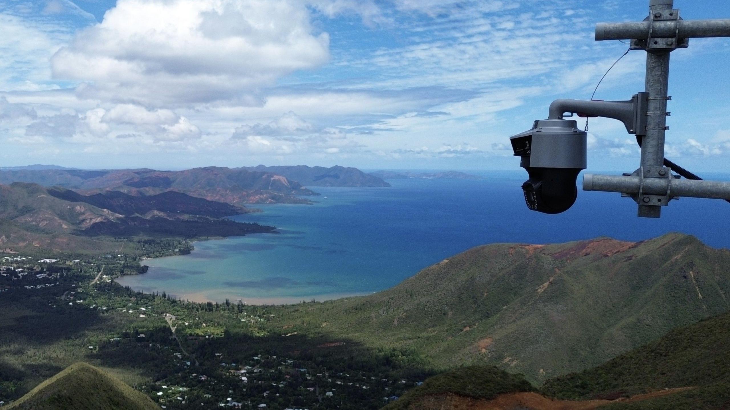 A camera overlooks a mountainous regions near the sea in France.