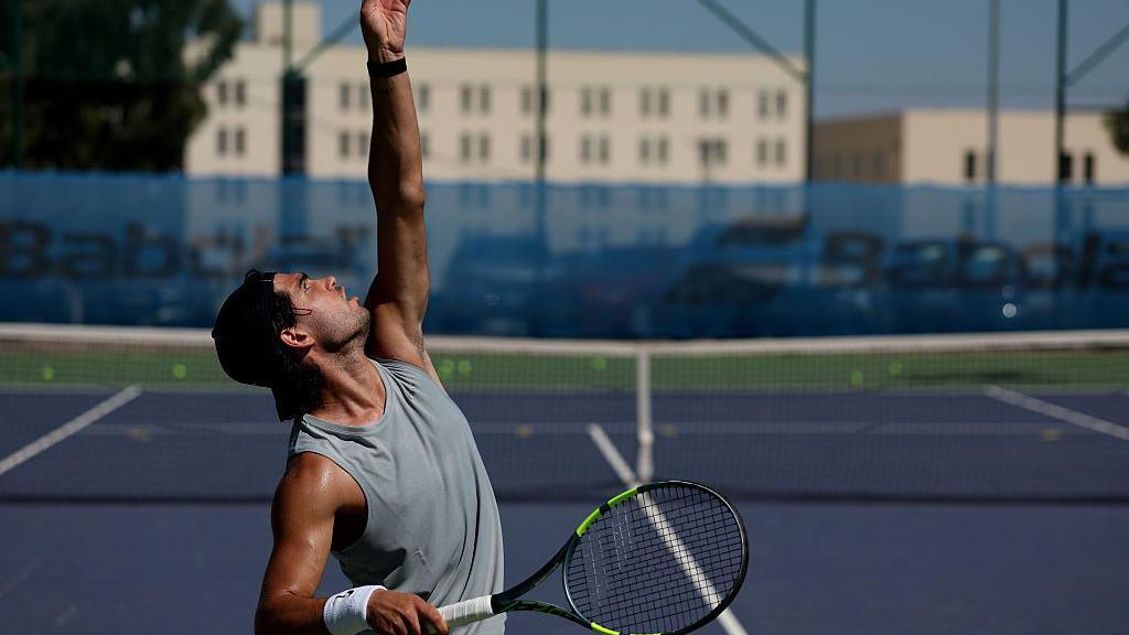 Carlos Alcaraz tosses before a serve during a tennis training session in Murcia, Spain