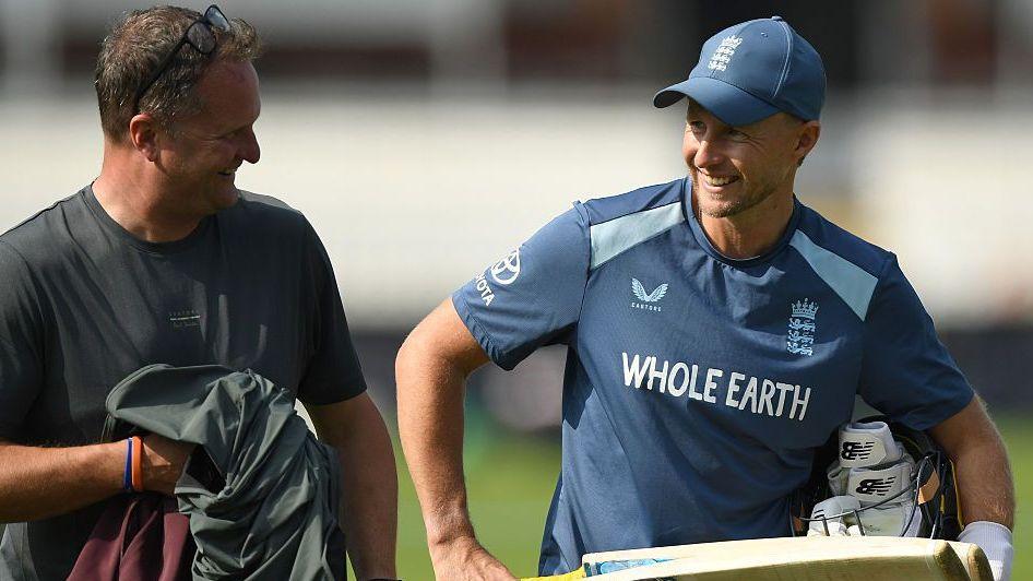 England Test captain Joe Root holding a bat and talking to Rob Key