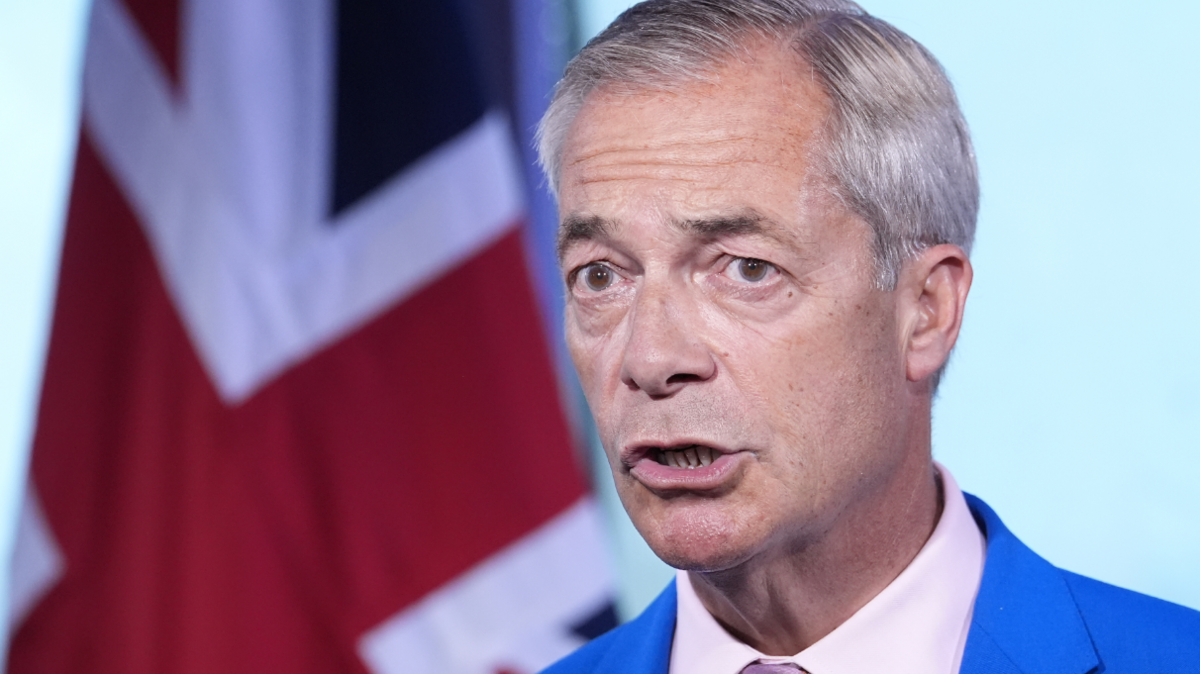 Reform UK leader Nigel Farage makes a statement with a union jack in the background