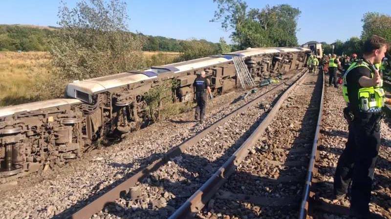 A number of the carriages which derailed tumbled into a field next to the railway
