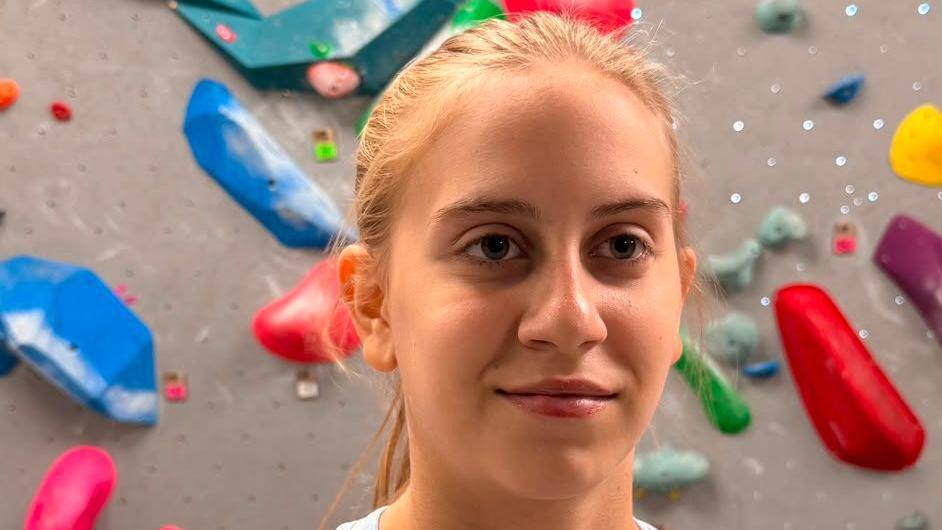 Mary Falconer in front of a bouldering wall
