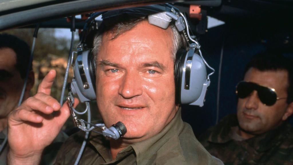 Ratko Mladić is photographed wearing ear defenders in a military helicopter during the Bosnian War in 1994