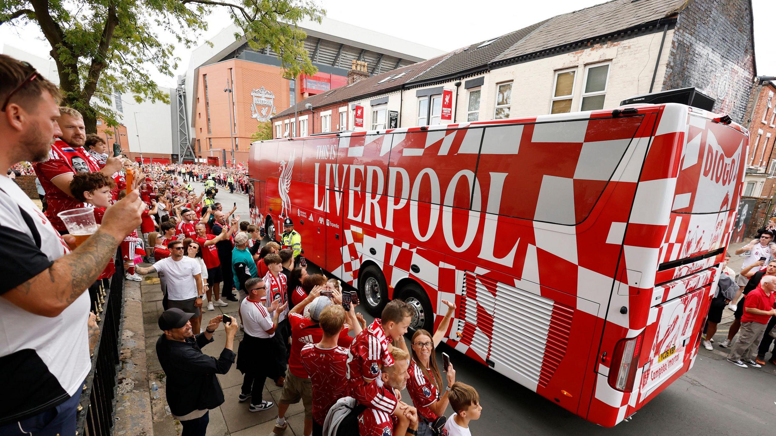 Liverpool fans greet the team bus outside Anfield
