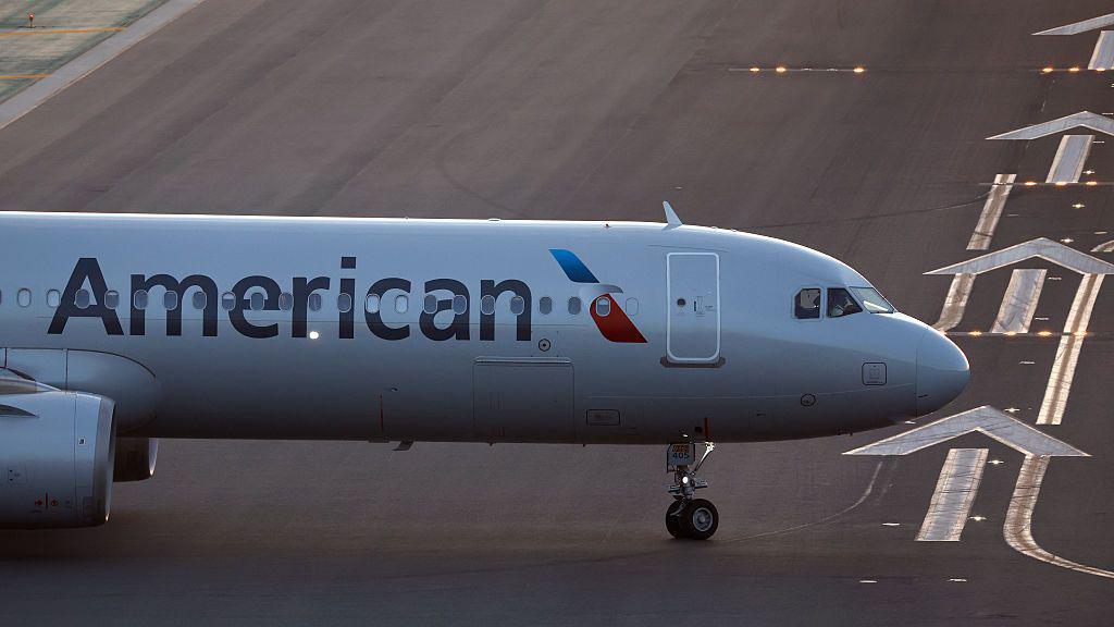 The front of an air plane with the American logo on a runway.