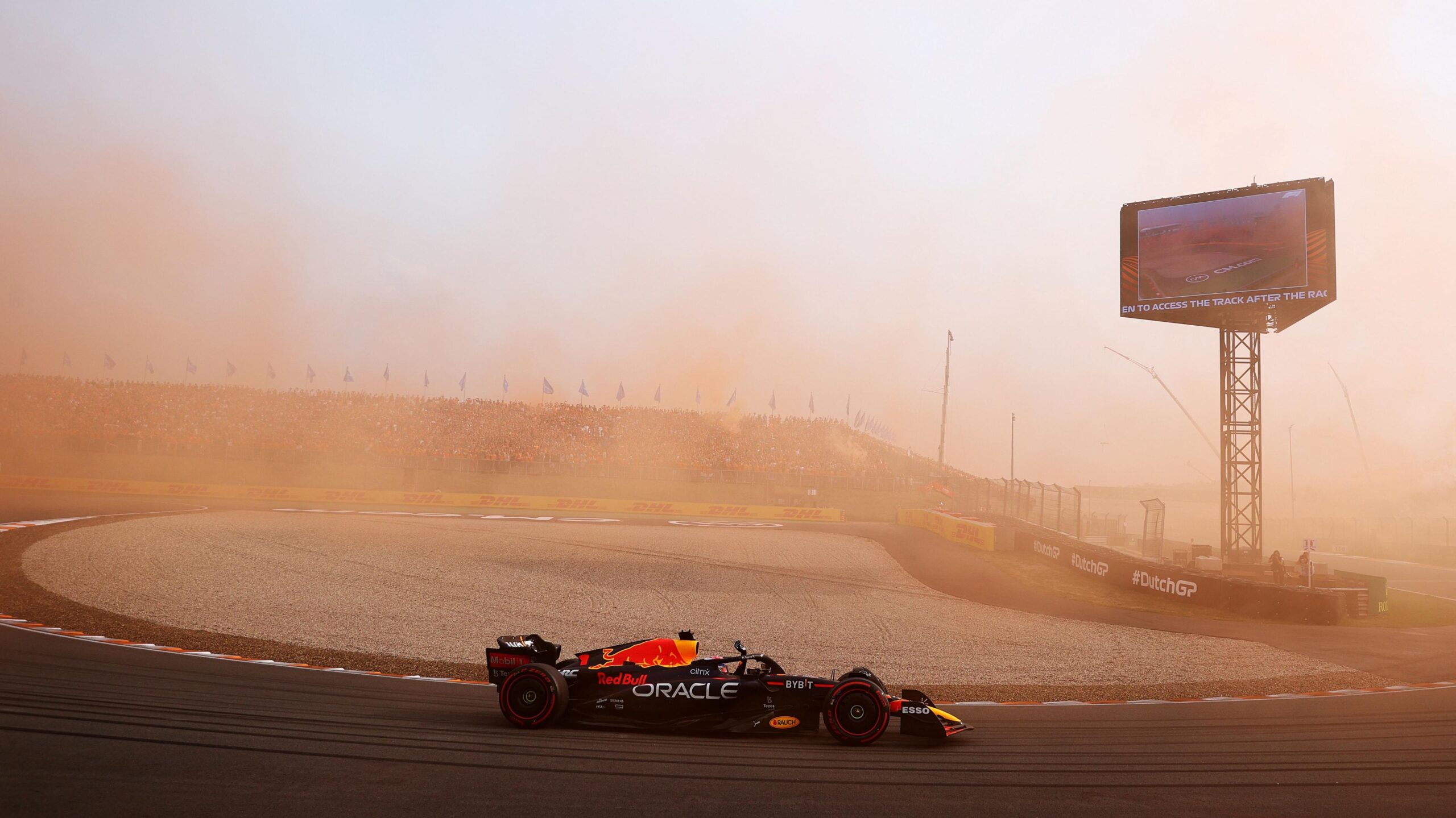 Red Bull's Max Verstappen drives around a hairpin with orange smoke in the air after Dutch fans let off flares during the 2022 grand prix